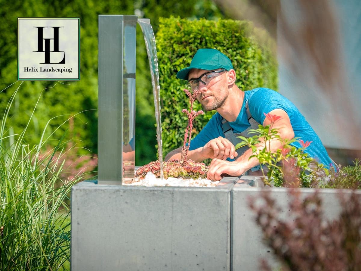 Helix Landscaping expert installing a modern water feature for a custom garden design