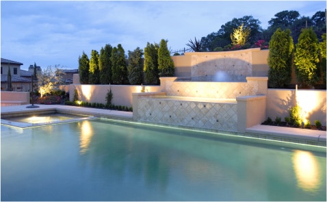 Elegant Pool Design with Natural Stone Waterfall and Lush Landscaping