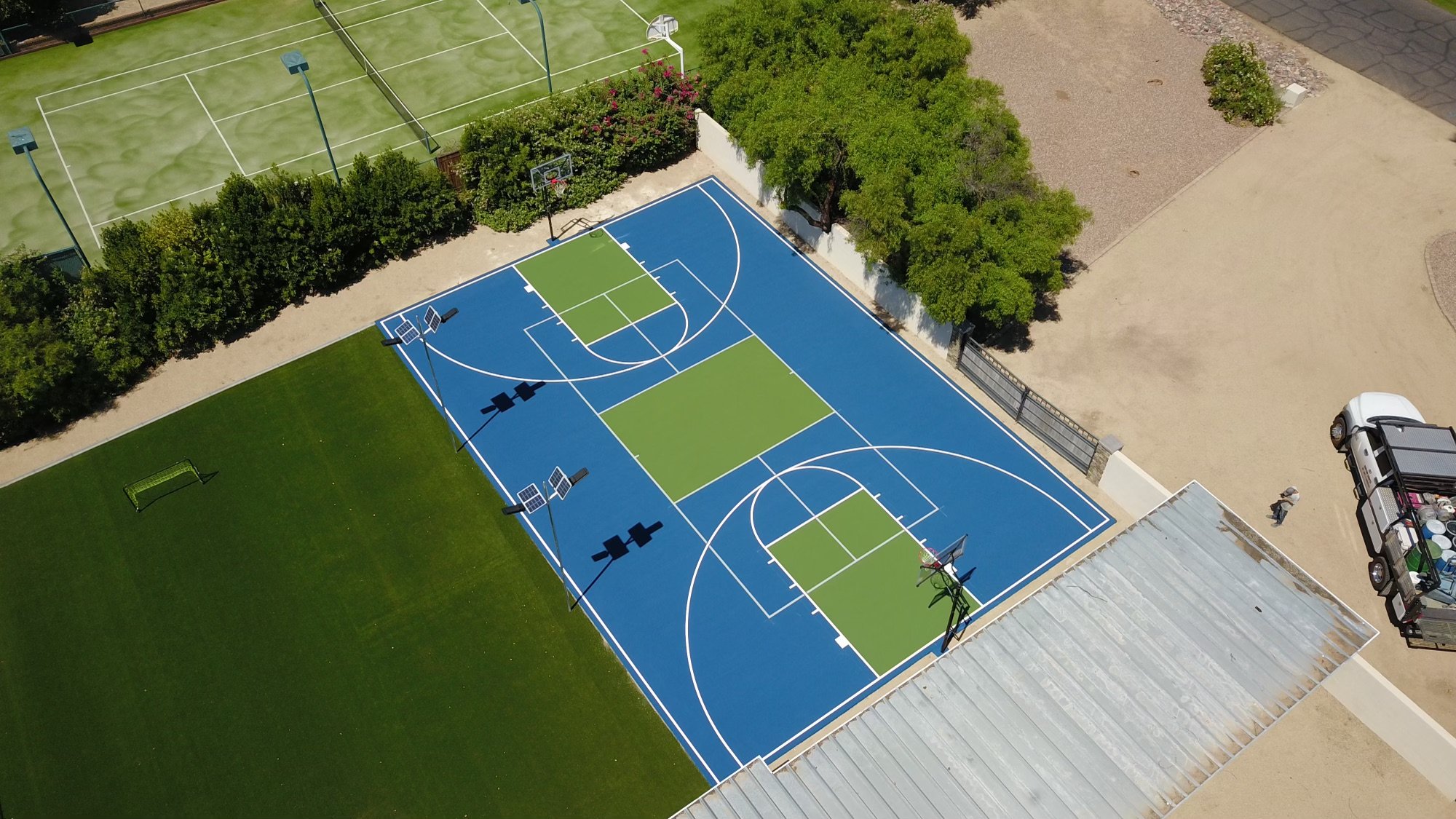 Multi-functional basketball and tennis court, and green turf area