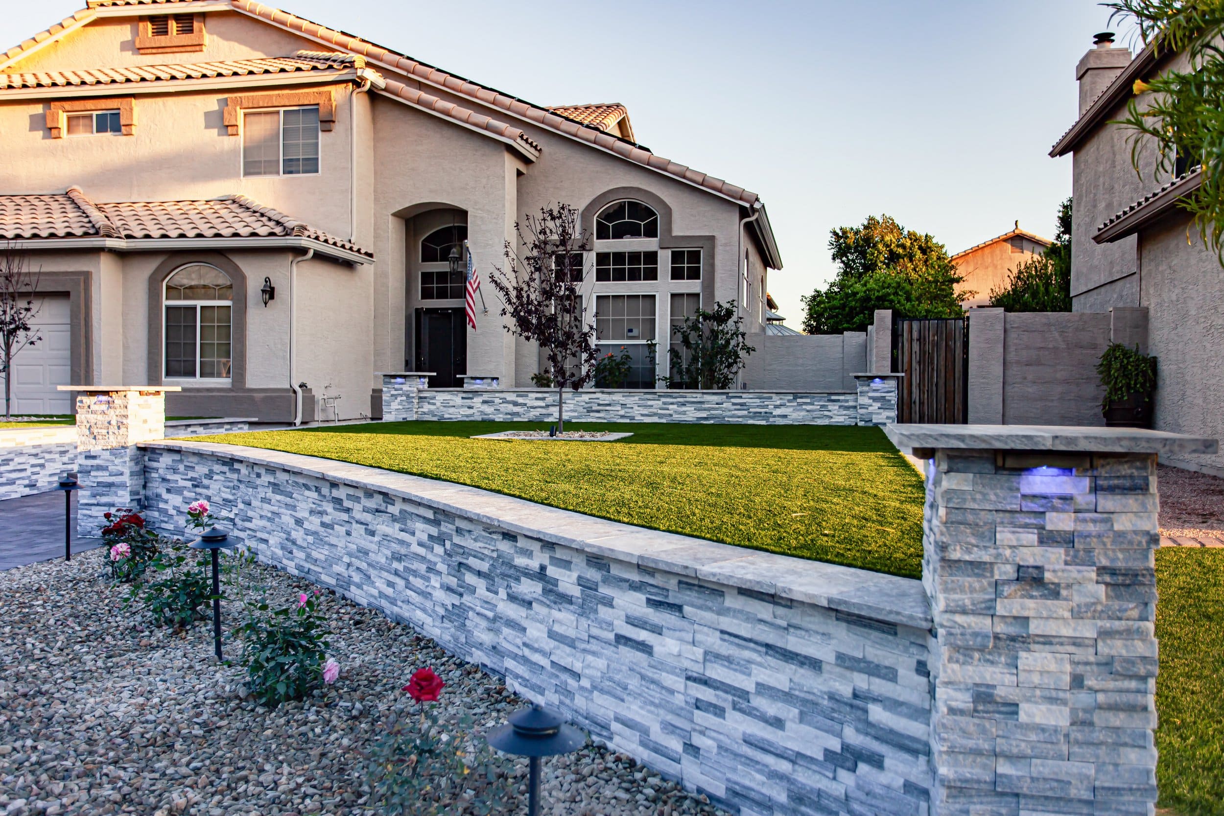 Exterior of a home with decorative stone wall, and artificial grass